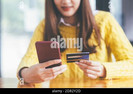 business Online Shopping Concept. Closeup hands holding credit card and using smartphone. Stock Photo