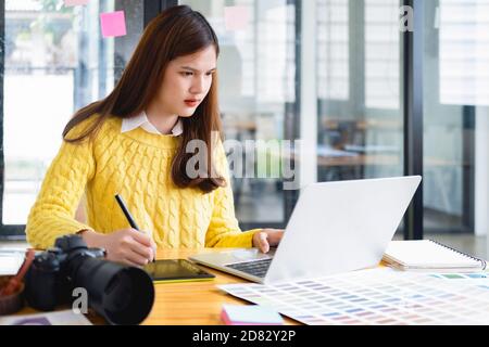 Professional photographer editing photos by laptop. Photo editor retouching photos. Stock Photo