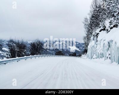 Driving through snowy white road and landscape in Norway. Stock Photo