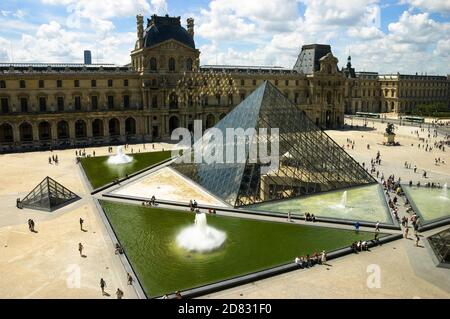 Overview of Louvre's courtyard main entrance facing Pavillon Richelieu Wing, glass pyramid and fountains, Paris, France. Stock Photo