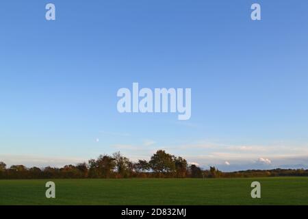 Decaying storm clouds in a clear sky on an autumn evening at Downe, Kent, once home to Charles Darwin. Clouds seem luminous and glowing as sun sets Stock Photo