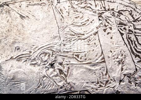 Milano -10/101/2020: wrinkled sheet of crushed tin aluminum silver foil background Stock Photo