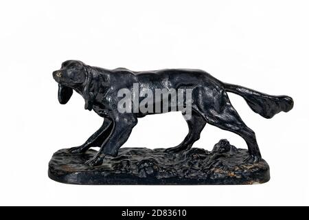 Old cast iron figurine of a black dog isolate on a white background close-up. Stock Photo