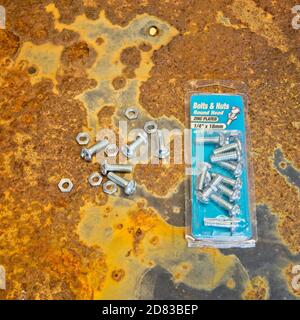 Nuts and bolts package on rusty background surface Stock Photo