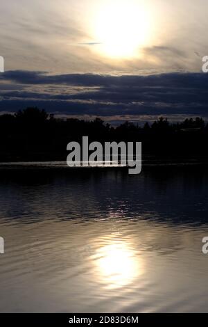 Setting sun and reflection in a calm Dow's Lake on a fine Fall day in Ottawa, Ontario, Canada. Stock Photo