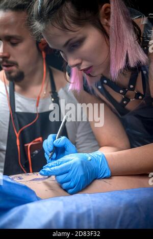 Professional tattoo artist working on professional tattoo machine device in tattoo studio Stock Photo