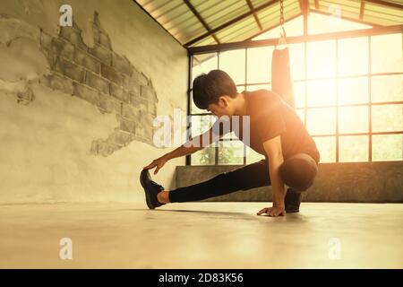 Man stretching out muscles in gym before exercise. Stock Photo