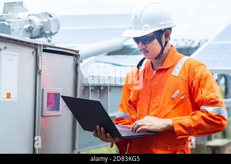 Engineers used a laptop for checking the performance of the controller box to confirming systems working normally. Concepts professional engineer for Stock Photo