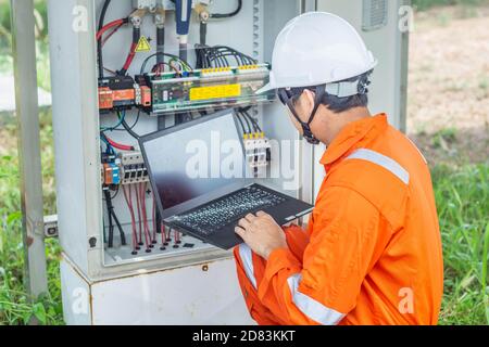 Engineers upload data of power energy to a laptop for checking the performance of the solar panel to confirming systems working normally. Concepts pro Stock Photo