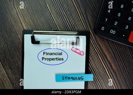 Financial Properties and Stimulus write on sticky note and isolated on Wooden Table. Finance Concept Stock Photo
