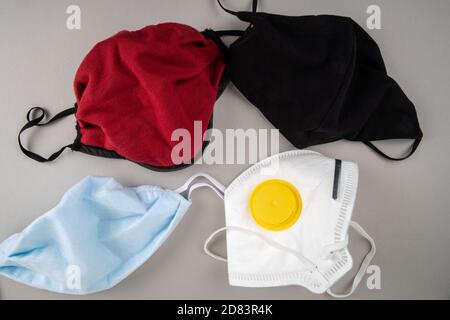 Different color face masks on a gray background. Virus spread, regulations and public safety concept. Stock Photo