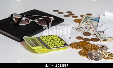 money, calculator, pen, paper, notebook and glasses on white background, financial analytics concept, calculating budget, flat lay, close-up Stock Photo