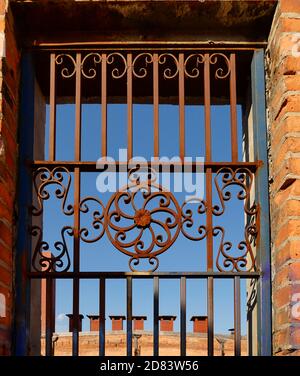 Iron gate on old brick building Stock Photo