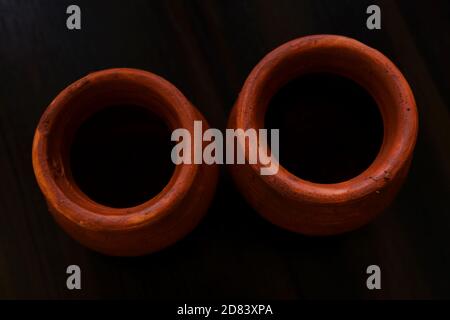 a top view of handmade little clay pots isolated on brown table Stock Photo