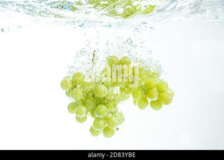 Fresh Muscat white Grapes Falling Into Water, Isolated on White Background Stock Photo