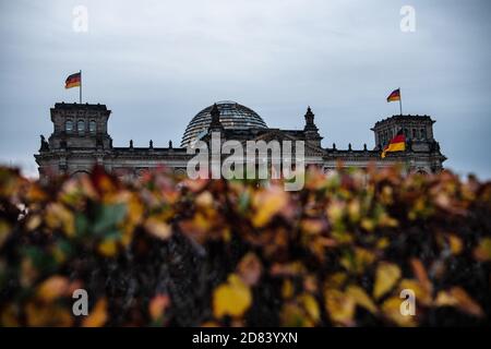 Berlin, Germany. 27th Oct, 2020. The Reichstag building can be seen behind autumnally coloured leaves. Credit: Paul Zinken/dpa-Zentralbild/dpa/Alamy Live News Stock Photo