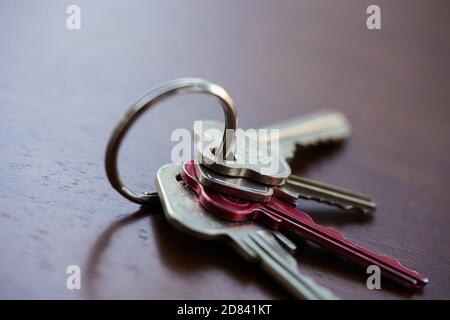 Set of house keys on a keyring sitting on a table Stock Photo