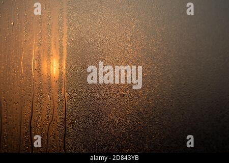 Drops of water on the fogged glass in the morning light. Selective focus. Background. Stock Photo