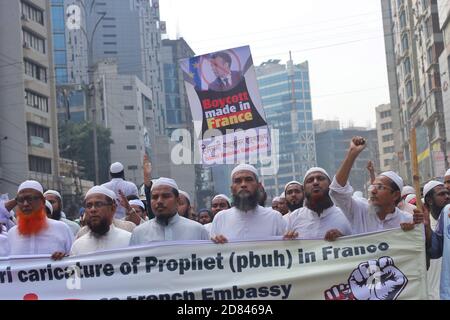Muslim protesters hold a banner during the protest in Dhaka.The Islami Andolon, one of Bangladesh's largest Islamist parties, hold a protest march calling for the boycott of French products and denouncing French president Emmanuel Macron for his remarks ‘not to give up cartoons depicting Prophet Mohammed’. Macron's remarks came in response to the beheading of a teacher, Samuel Paty, outside his school in a suburb outside Paris earlier this month, after he had shown cartoons of the Prophet Mohammed during a class he was leading on free speech. Stock Photo