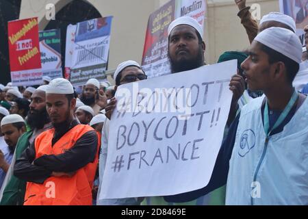 A Muslim protester is seen holding a placard reading ' #Boycott Boycott!!#France' during the protest in Dhaka.The Islami Andolon, one of Bangladesh's largest Islamist parties, hold a protest march calling for the boycott of French products and denouncing French president Emmanuel Macron for his remarks ‘not to give up cartoons depicting Prophet Mohammed’. Macron's remarks came in response to the beheading of a teacher, Samuel Paty, outside his school in a suburb outside Paris earlier this month, after he had shown cartoons of the Prophet Mohammed during a class he was leading on free speech. Stock Photo