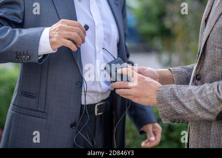 Close-up of two pairs male hands holding headset Stock Photo