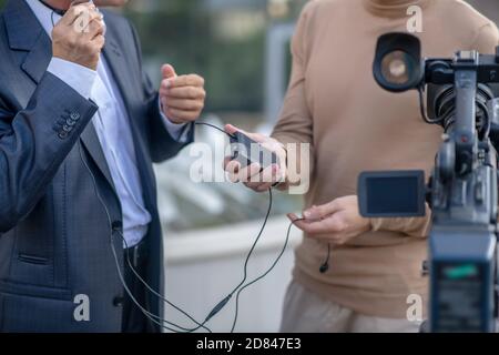 Close-up of two pairs of male hands holding headset in front of camera Stock Photo