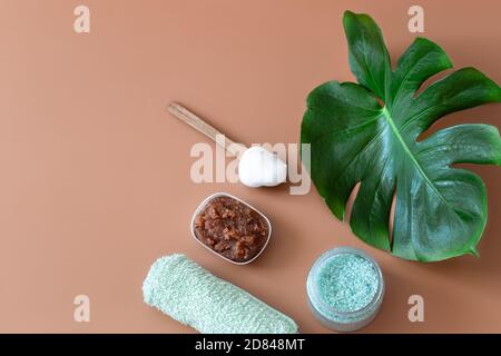 Spa composition with body care items on a colored background with a Monstera leaf . Spa concept. Stock Photo