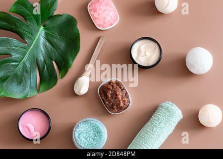 Spa composition with body care items on a colored background with a Monstera leaf . Spa concept. Stock Photo