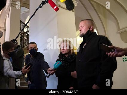 Berlin, Germany. 27th Oct, 2020. The parents (r) of a young woman killed in a traffic accident talk to journalists in front of a courtroom in the Tiergarten district court. The prosecution accuses a 53-year-old police officer of negligent homicide. In January 2018, he is said to have crashed into the car of a 21-year-old girl during an emergency drive at excessive speed near Alexanderplatz. The woman died at the scene of the accident. Credit: Paul Zinken/dpa/Alamy Live News Stock Photo