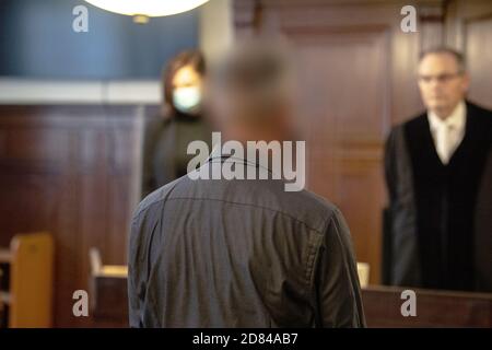 Berlin, Germany. 27th Oct, 2020. An accused policeman (M) is standing in a courtroom in the Tiergarten district court. The prosecution accuses the 53-year-old officer of negligent homicide. In January 2018, he is said to have crashed into the car of a 21-year-old girl during an emergency drive at excessive speed near Alexanderplatz. The woman died at the scene of the accident. Credit: Paul Zinken/dpa - ATTENTION: The defendant was pixelated by order of the court./dpa/Alamy Live News Stock Photo