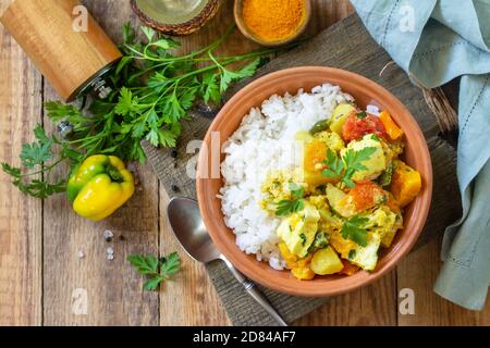 Indian cuisine dish sabji. Traditional Indian vegetable stew with soft cheese and turmeric on a wooden table. Top view flat lay background. Stock Photo