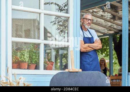 Middle aged caucasian man leaning on garden house wall Stock Photo