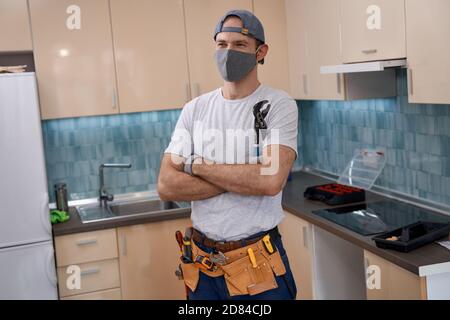 Young caucasian worker in mask holding wrench in hands Stock Photo