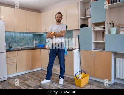 Young caucasian man standing with crossed hands in kitchen Stock Photo