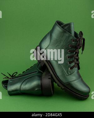 Green leather shoes. Winter and autumn off-season boots. Stylish boot isolated on background. Close-up. Laces, tractor sole, comfortable last. Casual Stock Photo