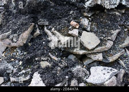 Broken pieces of asphalt at a construction site. Recycling and reuse crushed concrete rubble, asphalt, building material, blocks. Crushed сoncrete Stock Photo