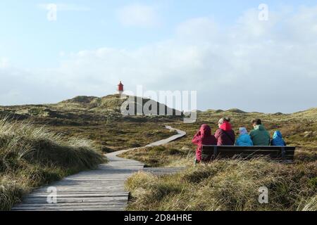 Family in front of wooden blanks path to Quermarkenfeuer, Isle of Amrum, North Frisian islands, Schleswig-Holstein, Germany Stock Photo