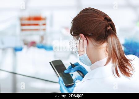 Young woman scientist using smartphone in the laboratory Stock Photo