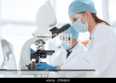 scientists testing the liquid and writing the results in a laboratory journal. Stock Photo