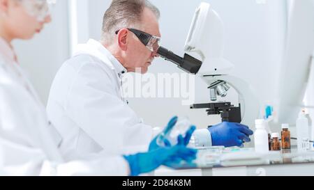 pharmacists from all over using microscope in the laboratory. Stock Photo