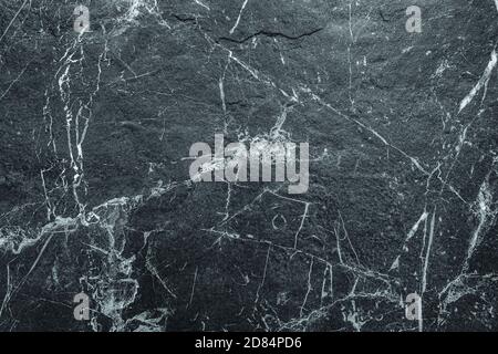 Dark Rough Marble Scratched Abstract Stone Wall Background. Abstract Texture Suitable for Backdrop, Wallpaper, or Decorative Design Stock Photo