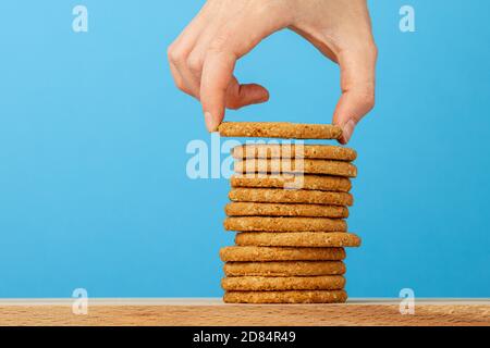 Human hand taking oat cookie from a stack Stock Photo