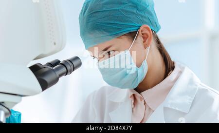 close up. female researcher looking through a microscope. Stock Photo