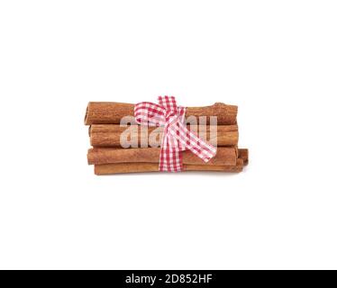dry cinnamon sticks tied with red ribbon, spice isolated on white background Stock Photo