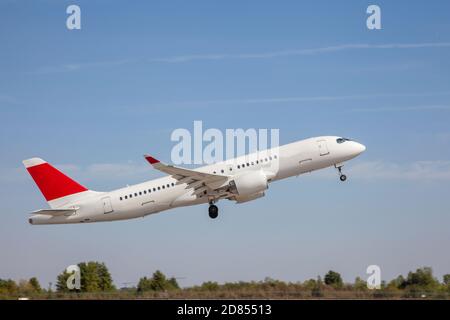 White plane flies in the sky. Takeoff and landing. Arrival and departure. Place for your text. Passenger plane isolated on blue background. Passenger Stock Photo
