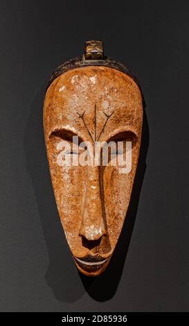 Santa Cruz de Tenerife/Spain; March 22 2019: Antique  african Fang Ngil wooden mask, from Cameroon,  on grey wall surface Stock Photo