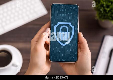 Woman using mobile phone, padlock icon on blue screen Stock Photo