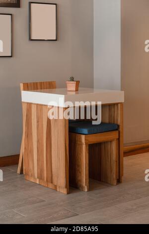 modern design of a table with chair and stool, in a room with checkered background, minimalist style Stock Photo