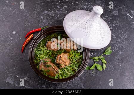 Braised pork ribs Chinese traditional food Serve with blanched kale in a ceramic pot. And sour sauce Stock Photo