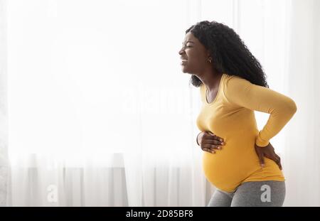 African american woman suffering from labor pains at home Stock Photo